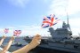 People with the UK national flag greet the Royal Navy’s flagship aircraft carrier, HMS Prince of Wales, departing Tokyo, Japan, on September 2, 2025. (Source: Getty Images)