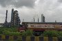 A tanker parks near an industrial facility as smoke rises from chimneys under overcast skies in Mumbai, India, on September 12, 2025. (Source: Getty Images)