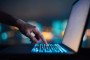 Close up of woman's hand typing on computer keyboard in the dark against colourful bokeh in background. Illuystrative image. (Photo: Getty Images)