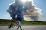 Local residents walk past the smoke from a fire at the Russian e-commerce firm Wildberries' logistics complexes in the town of Elektrostal, outside Moscow, on July 18, 2026. (Source: Getty Images)