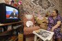 A woman watches Russian leader Vladimir Putin's address to the nation in a pre-recorded TV speech. (Source: Getty Images)