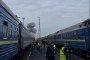 Passengers stand between trains as smoke rises near a railway station following a Russian attack. (Source: Pivden)