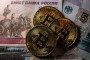 Illustrative image: Bitcoin tokens are photographed alongside Russian rouble bank notes. (Source: Getty Images)