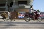 A motorcyclist and a cyclist ride past “House For Sale” signs in Koh Samui, Surat Thani province, Thailand, on Thursday, January 18, 2018. (Source: Getty Images)