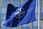 A NATO flag flies in the wind in front of the NATO headquarters in Brussels. (Source: Getty Images)