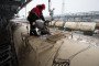 A worker overseas the loading of oil supplies into freight wagons at the Lukoil-Nizhegorodnefteorgsintez oil refinery, operated by OAO Lukoil, in Nizhny Novgorod, Russia, on December 4, 2014. (Source: Getty Images)