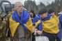 Freed Ukrainian prisoners of war wrapped in national flags gather after a prisoner exchange, shortly after returning from Russian captivity on March 5. (Source: Office of the President of Ukraine)