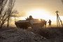 Ukrainian servicemen take cover behind a military armored vehicle during drills east of Kyiv, Ukraine, March 28th, 2022.