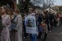 A Russian dissident holds a placard reading “My candidate Alexei Navalny killed by Putin’s regime” as she waits in line in front of the Russian consulate on March 17, 2024 in Milan, Italy. (Source: Getty Images)