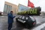 A man looks at the Lada VAZ 2109 car with Soviet flag and symbolic layout of the RS-28 "Sarmat" missile. (Source: Getty Images)