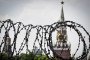 This photograph shows a view of the Kremlin taken on May 21, 2026, through the barbed wire of a municipal technical facility in Moscow.