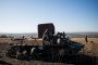 A volunteer searches a battlefield near the wreckage of a Russian armored personnel carrier in Ukraine's Donetsk region. (Source: Getty Images)