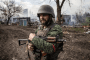 A Russian serviceman stands in front of destroyed buildings in Ukraine. (Photo: open source)